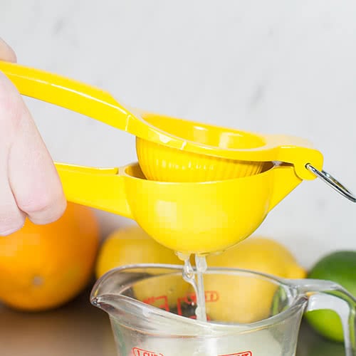 Juicing a lemon with a hand juicer