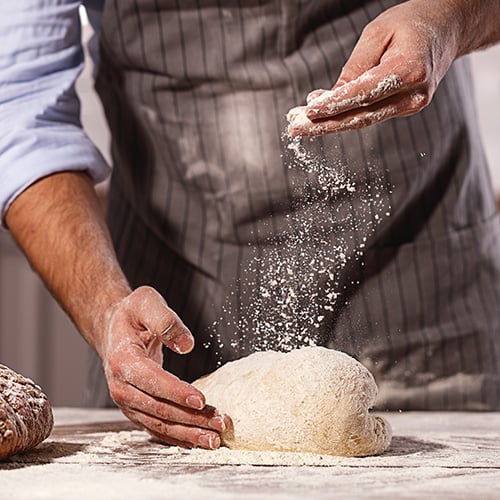 sprinkling bread flour on bread dough