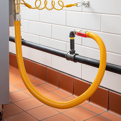 Yellow commercial gas hose connected to gas pipe