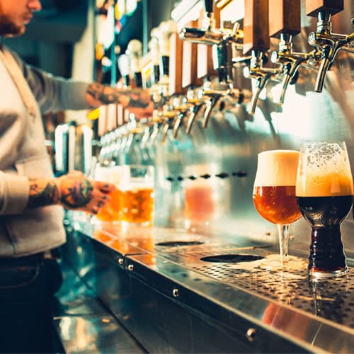 beer taps filling up different types of beer glasses