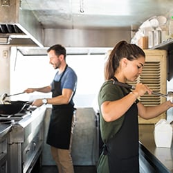 Food tuck owners working on food truck equipment