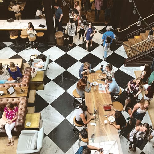 large food hall with communal seating and checkerboard flooring