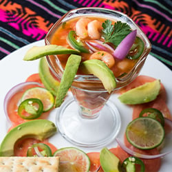a ceviche cocktail glass filled with shrimp, onions, and avocado 