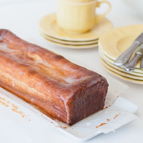 Freshly baked and homemade lemon pound cake with lemon sugar icing on white table
