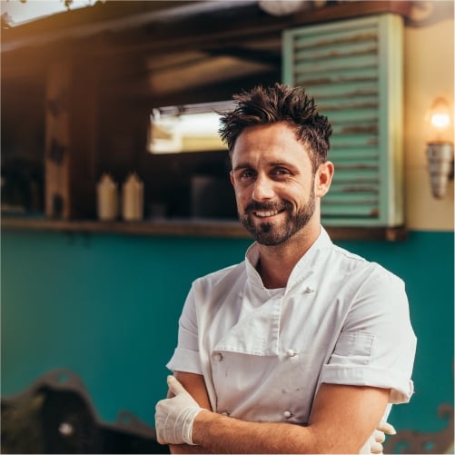 Happy food truck owner standing in front of truck