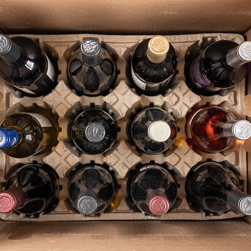 Dentro de una caja de envío llena de botellas de vino.