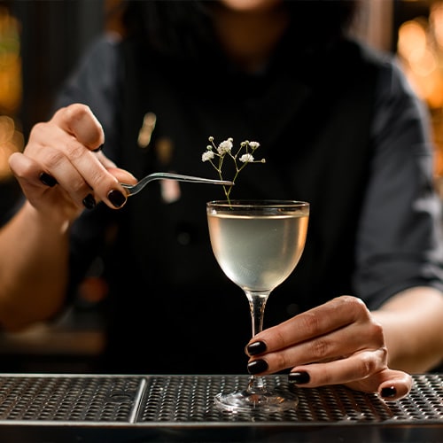 Bartender elaborando una bebida elegante con guarnición