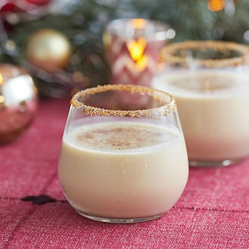 A glass of Eggnog Cocktail with crushed spiced cookies on the rim.