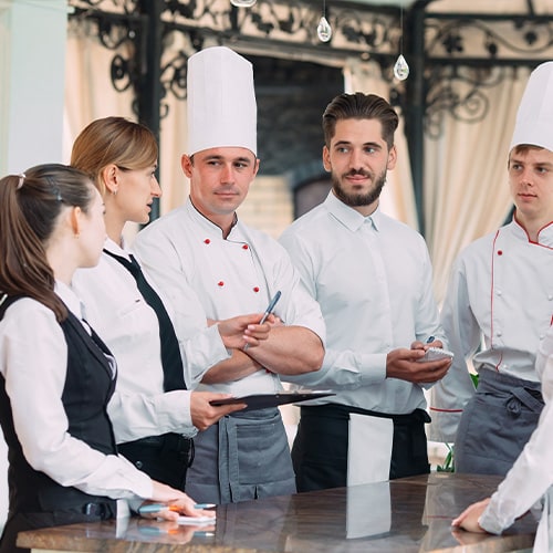 Restaurant manager and his staff in a meeting in the kitchen