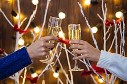Two people toasting with champagne and celebrating the holiday season