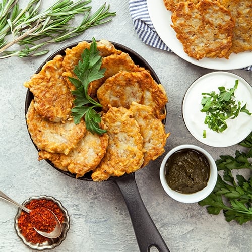 A skillet filled with latkes on a table.