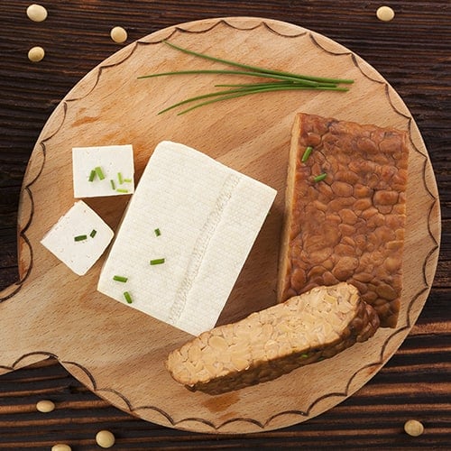 Tofu and tempeh on wooden background