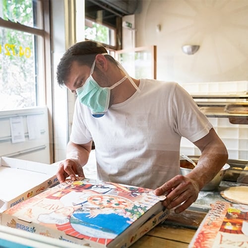 Worker preparing food order with face mask