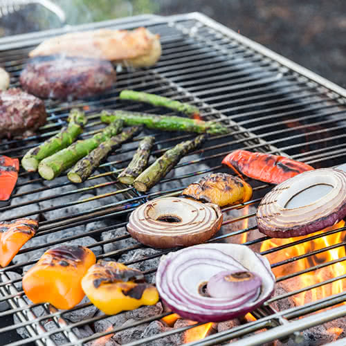 veggies and meat on a hot grill