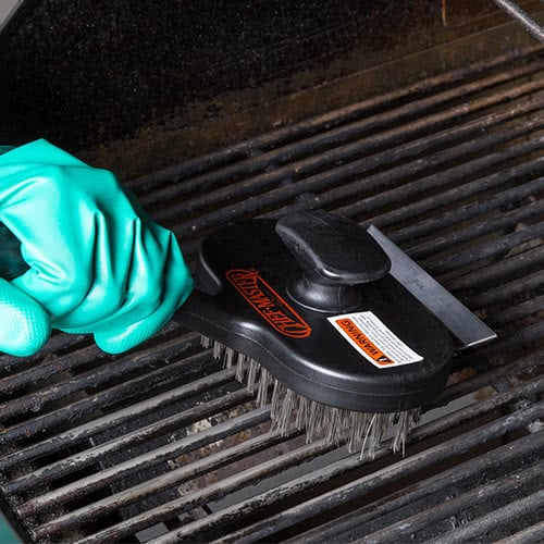 person cleaning grill grates