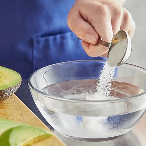 Citric Acid being poured into bowl with water