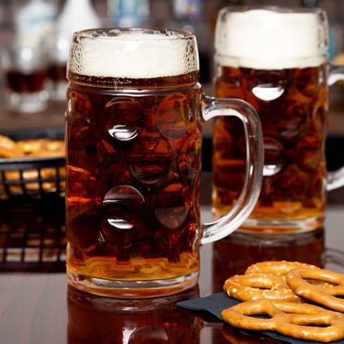 Oktoberfest beer in glass mugs with pretzels.