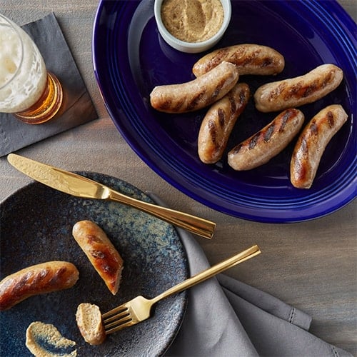 Oktoberfest meal with brats on blue plate.