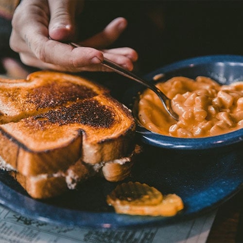 toasted grilled cheese sandwich and a bowl of mac and cheese