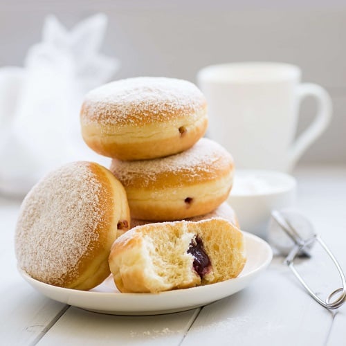traditional german polish donut with raspberry jam dusted with icing sugar
