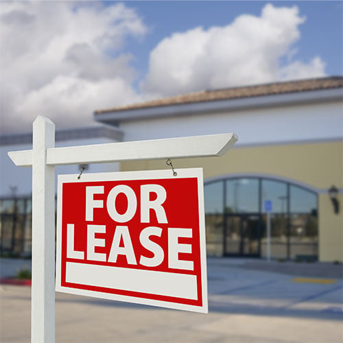 vacant retail building with for lease real estate sign