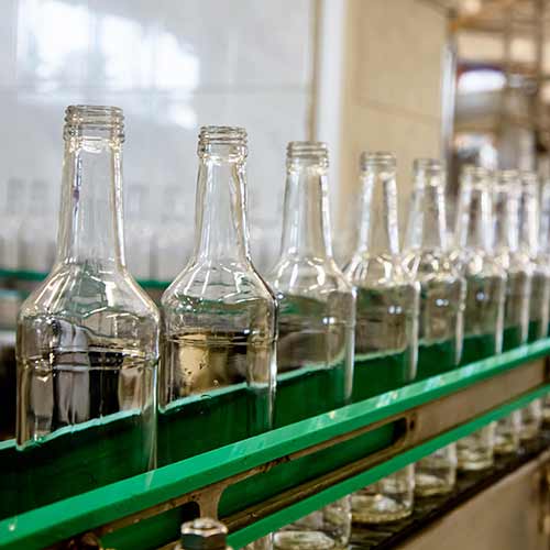 bottles moving on a conveyor belt at a factory for production