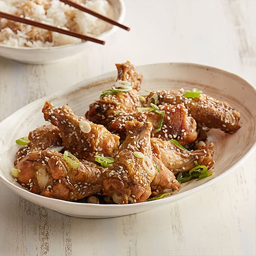 chicken wings with sesame seeds in a white dish