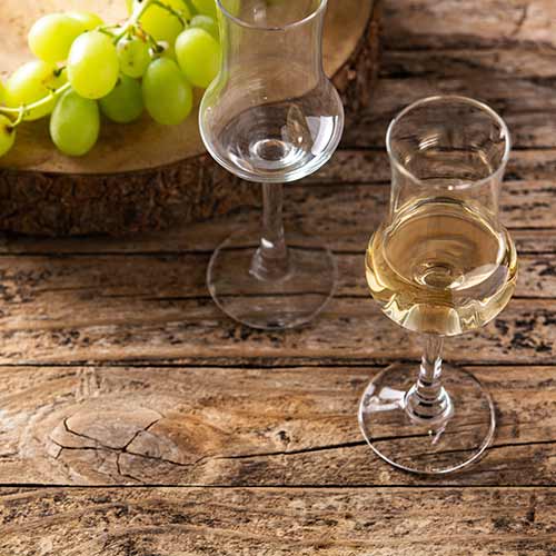 italian golden grappa drink on wooden background