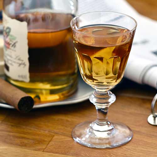 sherry in glass with cigar and bottle in background