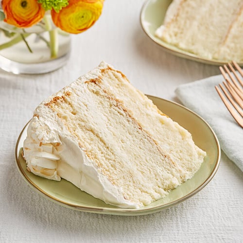 slice of white wedding cake topped with toasted coconut