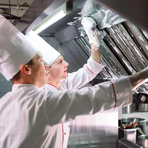 cooks wash oven stove and extractor in restaurant