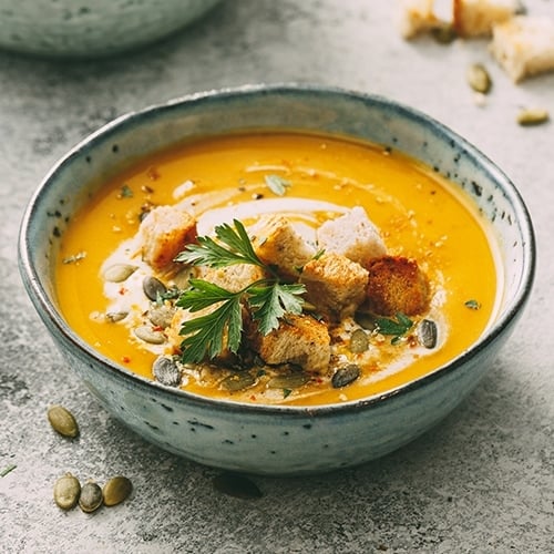 Bowl of pumpkin soup on counter