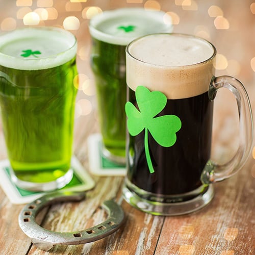 shamrock on glasses of beer and horseshoe on wooden table