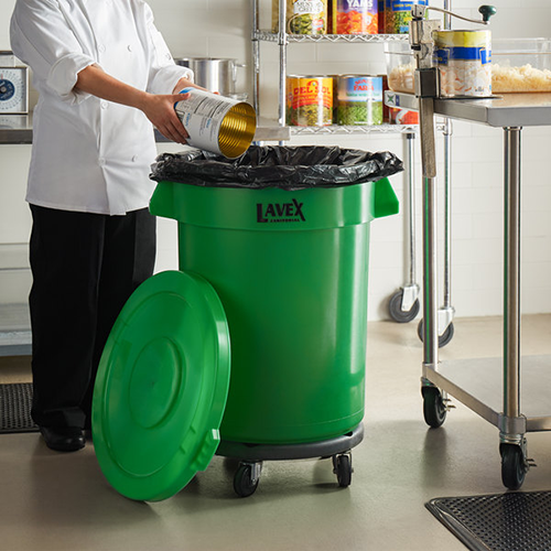 kitchen staff member emptying food into recycling bin