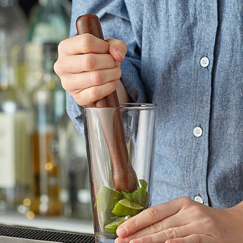 male bartender using wood muddler