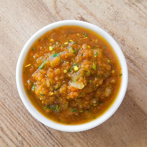 Salsa ranchera in white dish on wood background