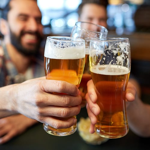 happy male friends drinking beer at bar