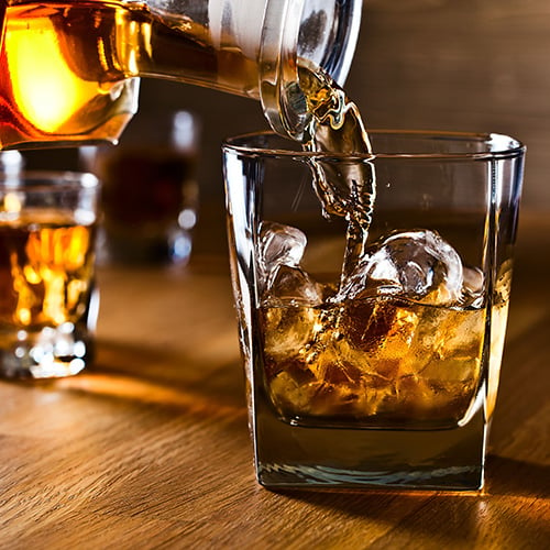 whiskey being poured over natural ice