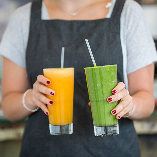 closeup shot of waitress serving freshly made avocado and mango juices at cafe