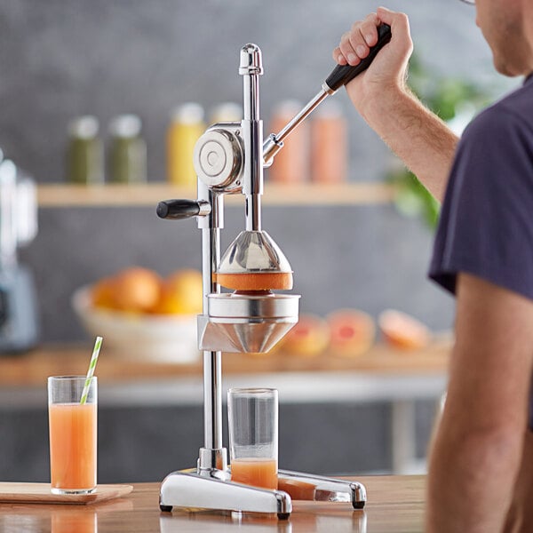 Juicing a grapefruit with a large free standing stainless steel juicer