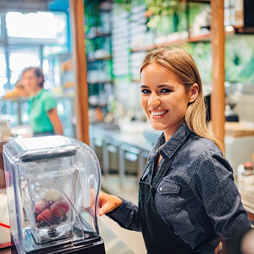 smiling waitress working at smoothie bar