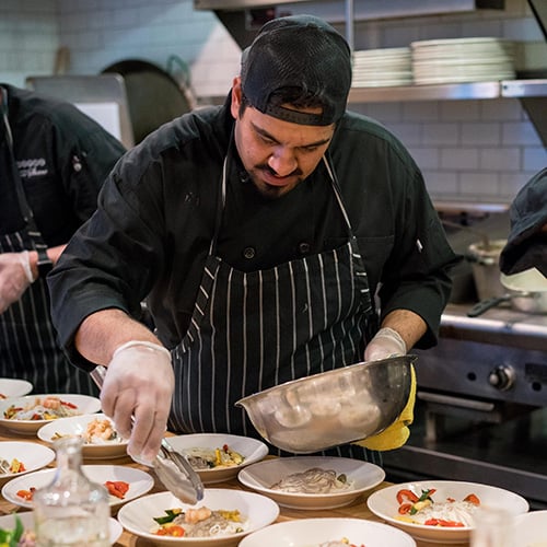 chef in professional kitchen plating food