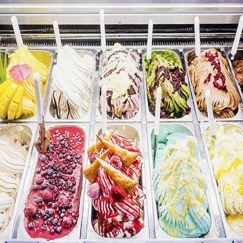 A view of several containers full of popular ice cream toppings on display  at a local ice cream shop. Stock Photo