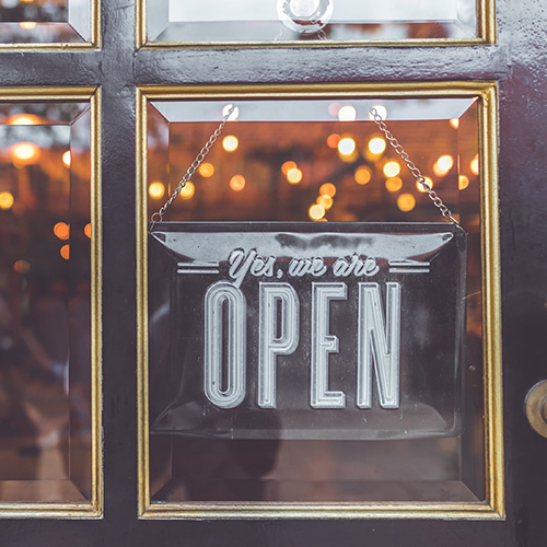 sign on restaurant door that says yes we are open