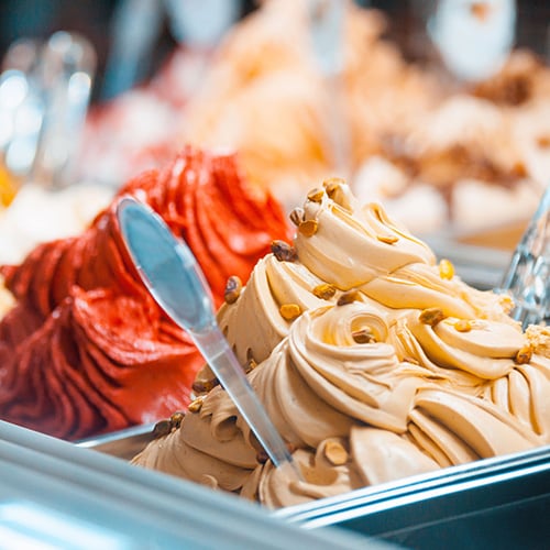 various flavors of italian gelato showcased in dessert shop