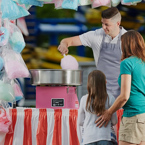 mother and daughter waiting for cotton candy from a pink carnival king branded cotton candy machine