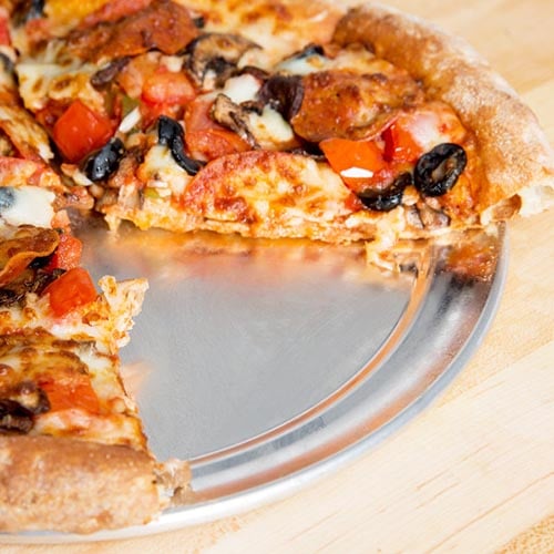 pepperoni olive tomato and mushroom pizza on pan with a slice removed