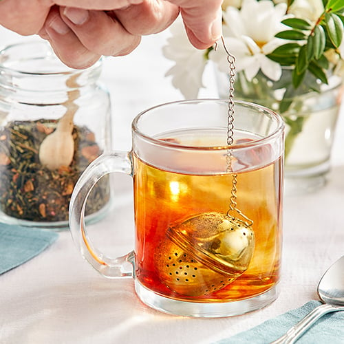 round stainless steel tea infuser in clear tea mug