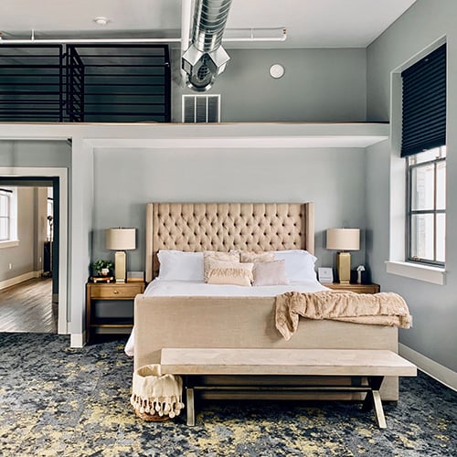 loft style bedroom with exposed ceiling and natural light