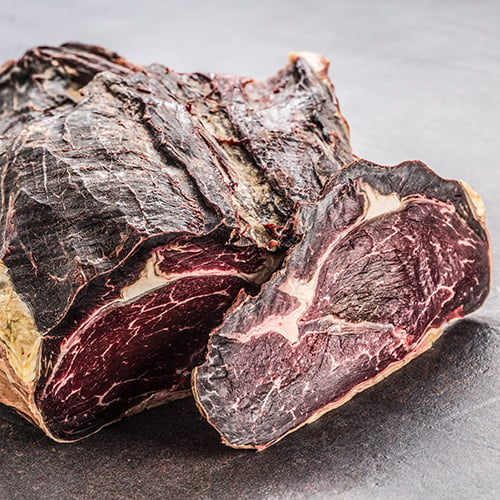 close up of dry aged beef on board in meat shop